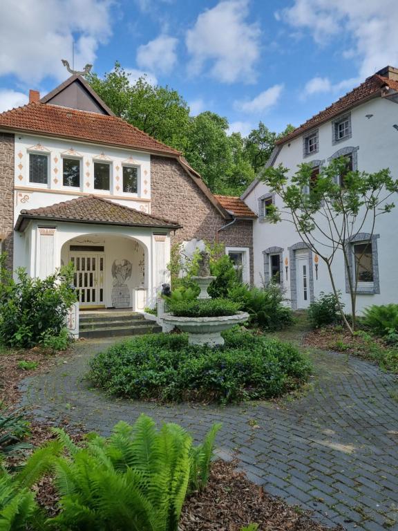 una casa con un camino de piedra que conduce a la puerta principal en Pension Zum Burgwächter, en Rahden