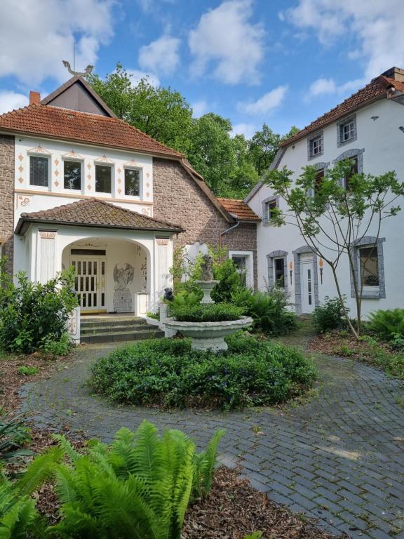 a house with a stone pathway leading to the front door at Pension Zum Burgwächter in Rahden