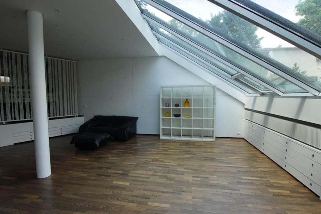 a living room with a couch and a large window at Maginifique villa d&#39;architecte sur les bords de Marne tout près de Paris in Le Perreux-Sur-Marne