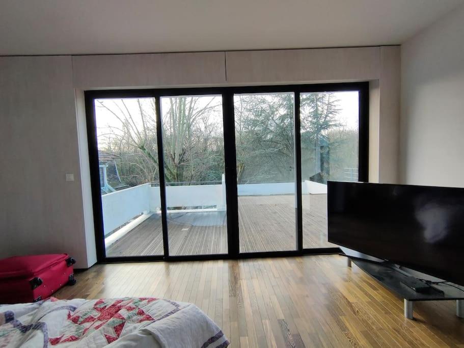 a bedroom with a large sliding glass door leading to a deck at Maginifique villa d&#39;architecte sur les bords de Marne tout près de Paris in Le Perreux-Sur-Marne