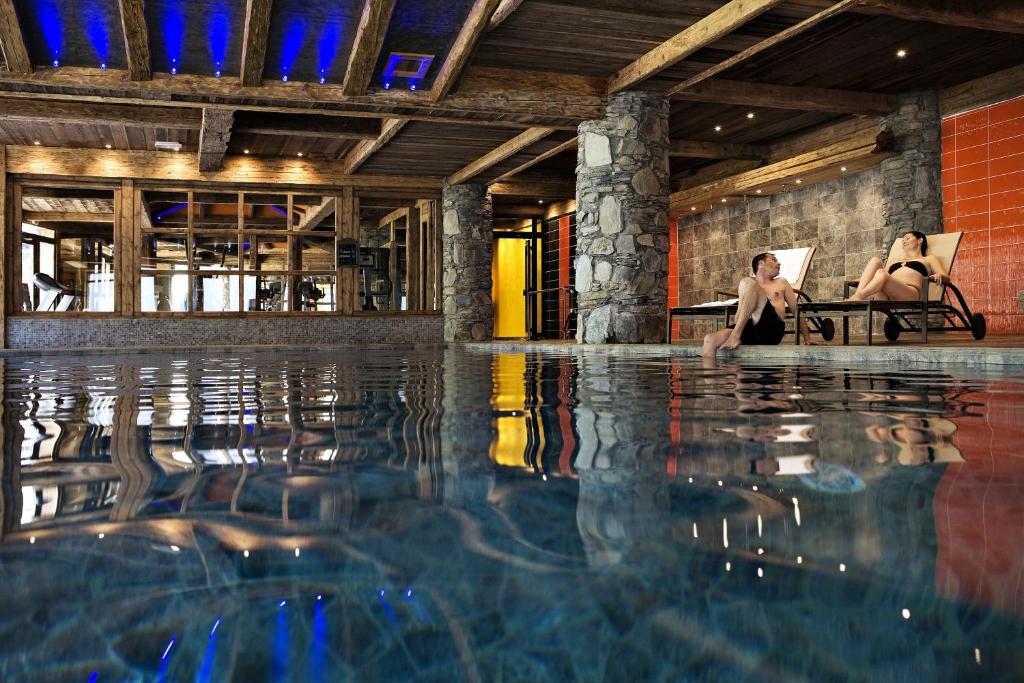 two women sitting in a swimming pool at CGH Résidences & Spas Le Nevada in Tignes