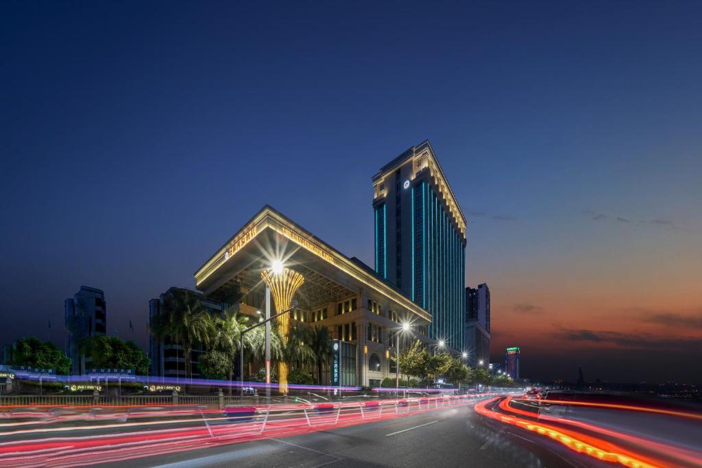 a building on a city street at night at Chongqing Hilman Homeful Hotel in Chongqing