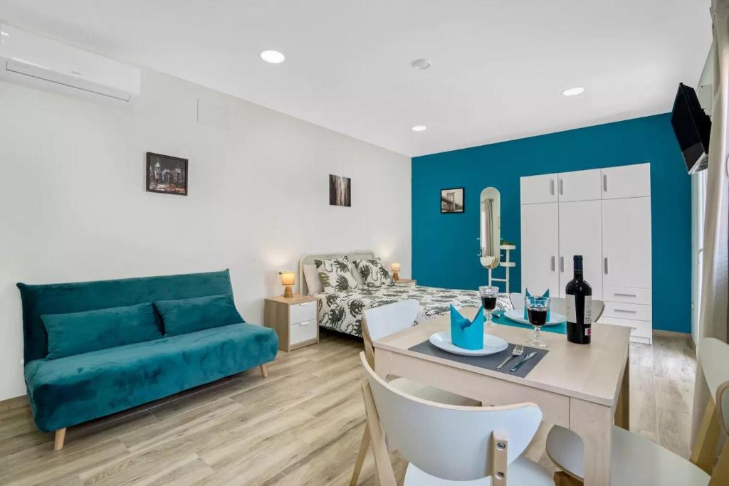 un soggiorno con divano blu e tavolo di Umihouse apartamentos centro Alicante ad Alicante