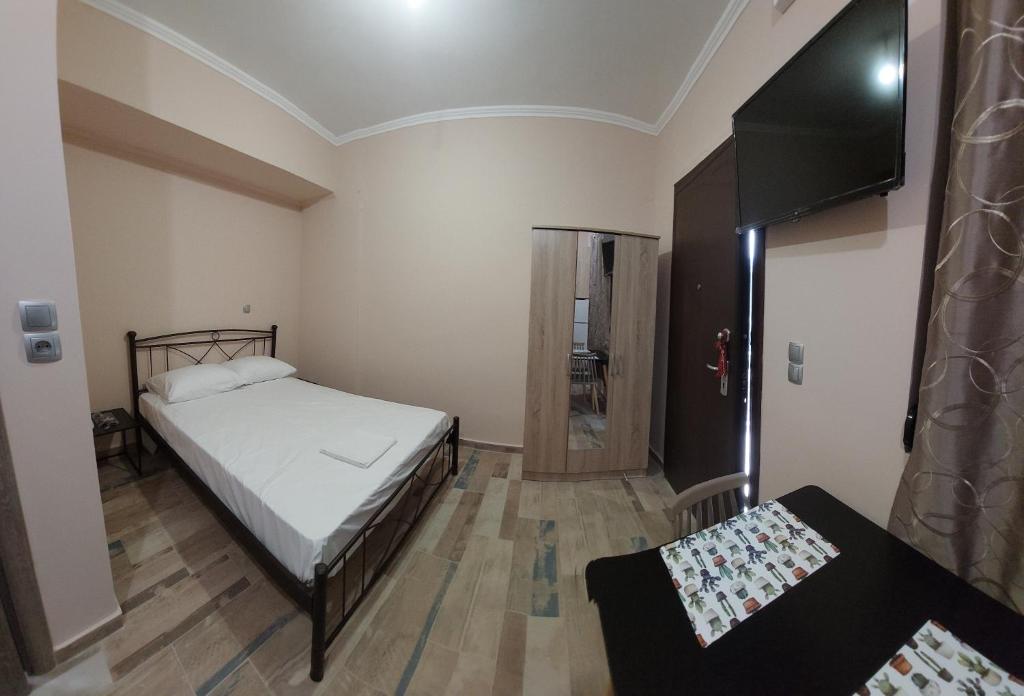 een kleine slaapkamer met een bed en een televisie bij Όμορφο στούντιο στη Χίο! Α2 in Chios