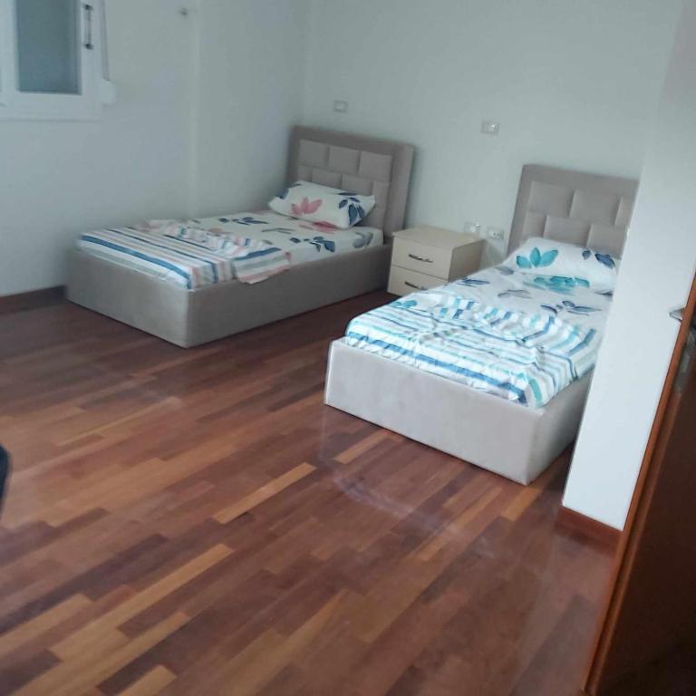 two beds in a room with a wooden floor at Villa Spinarica in Zverneci