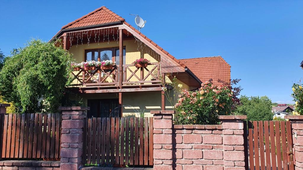 una casa con una valla y flores en la ventana en Privat ALMA, en Nová Lesná