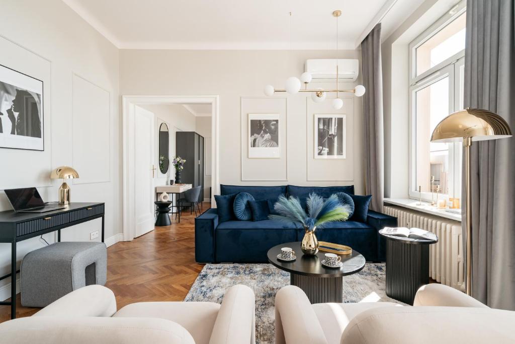 a living room with a blue couch and a table at Penthouse Panorama - LoftAffair in Kraków