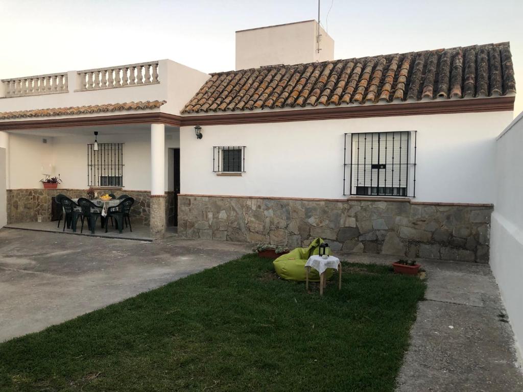 Casa blanca con pared de piedra y patio en Casa Campiña Jerezana 