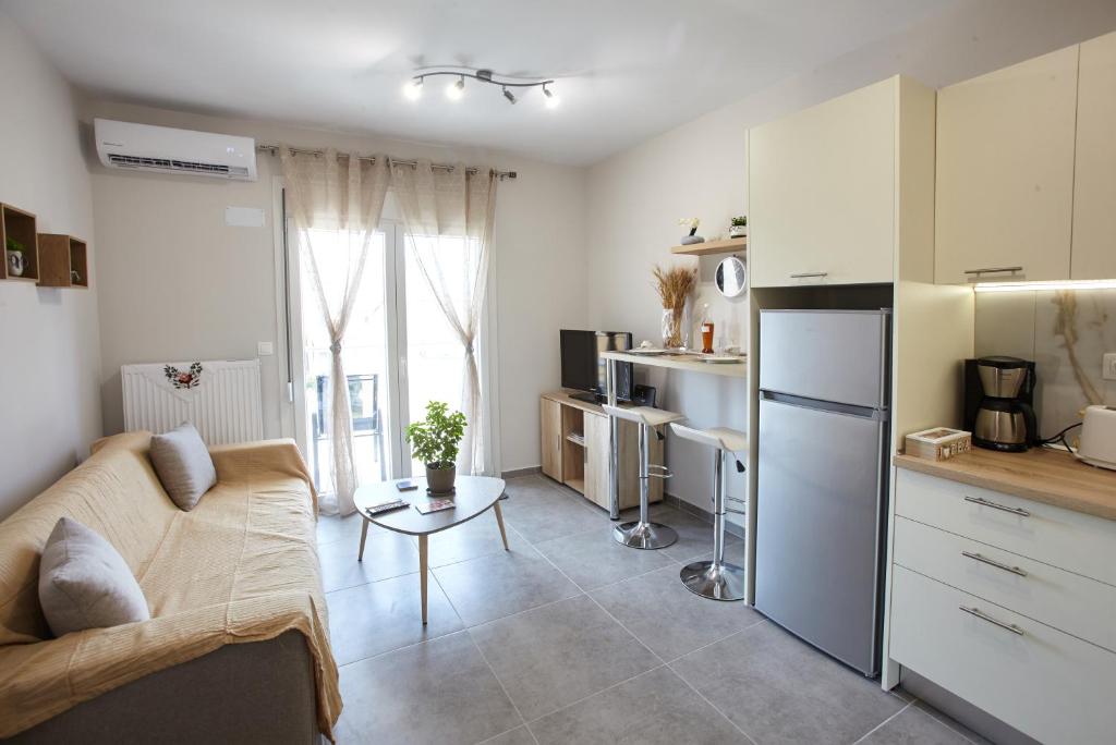 アレクサンドルポリスにあるPela's Apartment for Filoxeniaのキッチン、リビングルーム(ソファ、テーブル付)