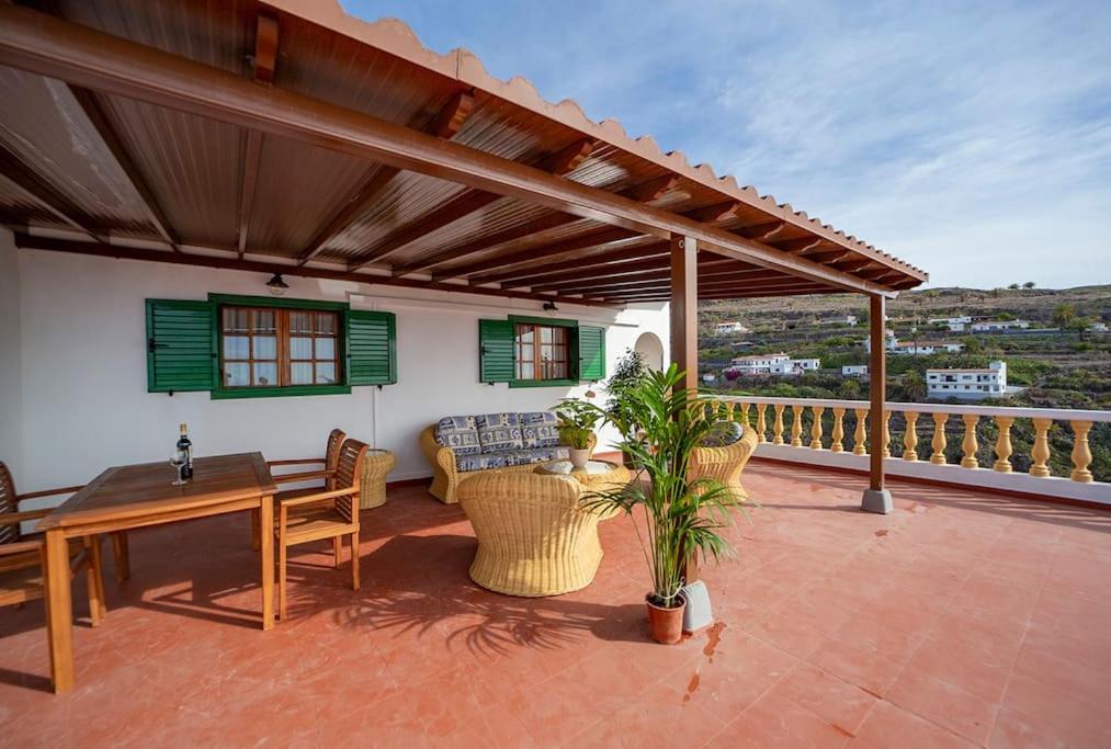 een patio met een tafel en stoelen op een dak bij Villa Teram in Alajeró