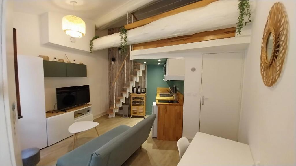 een woonkamer met een bank en een tafel bij Studio cosy, climatisation, quai de Saône, centre ville in Lyon