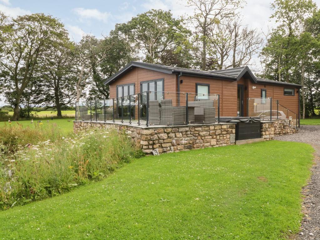 ein Blockhaus mit einer Terrasse und einem Hof in der Unterkunft Henry Haven in Preston