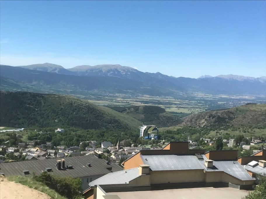 - une vue sur une ville avec des montagnes en arrière-plan dans l'établissement Charmant studio cabine 26m² avec belle terrasse, à Font-Romeu-Odeillo-Via