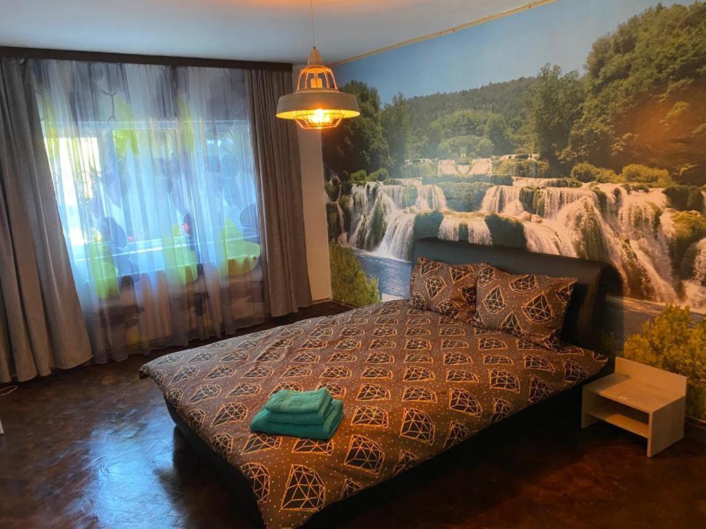 um quarto com uma cama com um quadro na parede em Ferienwohnung Violetta em Băile Herculane