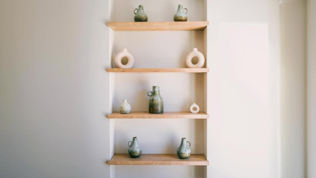 a bunch of vases sitting on wooden shelves at Hôtel L'Escalet in Ramatuelle