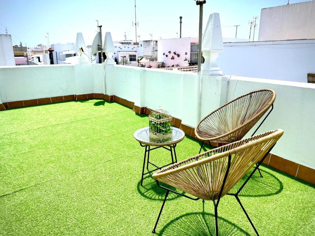 Casa Castelar by Bossh Apartments في روتا: كرسيين وطاولة على السطح