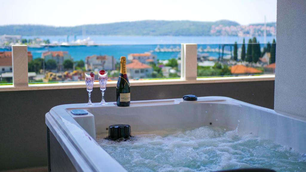 a bottle of champagne in a bath tub with a window at Luxury penthouse SkyView in Trogir