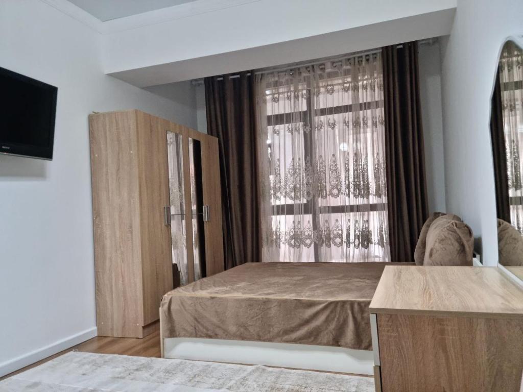 um quarto com uma cama e uma grande janela em Коттеджи в ЦО “Радуга» em Chon-Sary-Oy