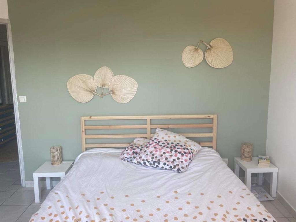 a bedroom with a bed with two fans on the wall at L'ambre salée in Gujan-Mestras