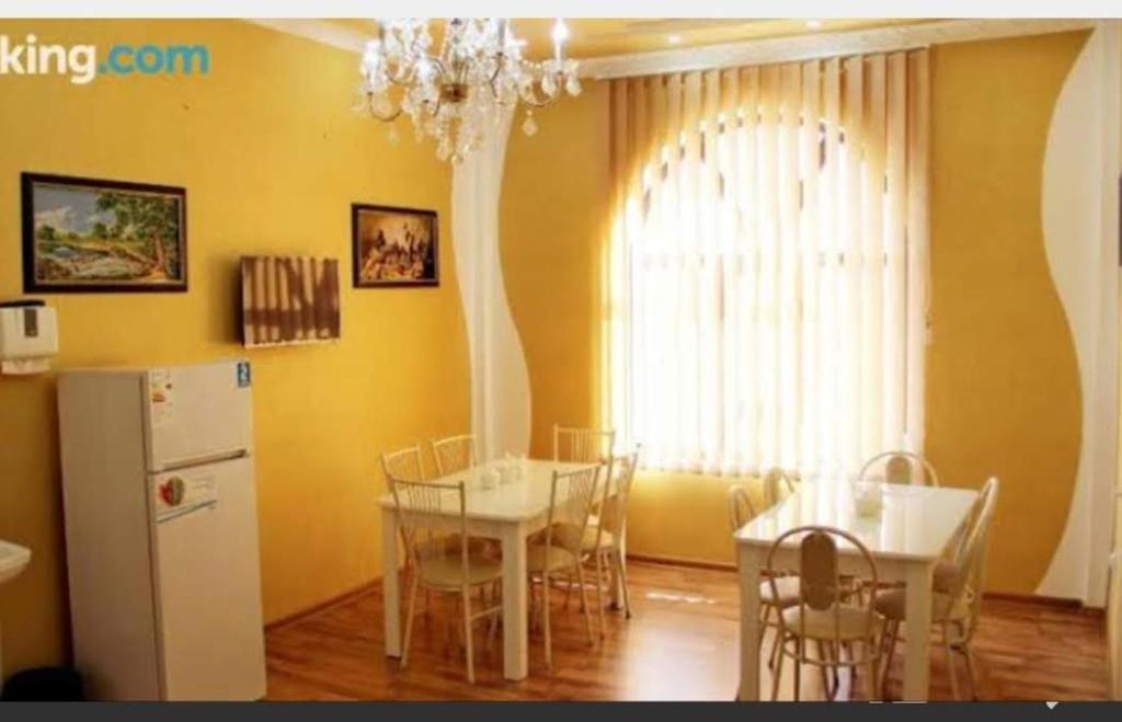 ein Esszimmer mit einem Tisch und einem Kühlschrank in der Unterkunft Hotel Zarafshon in Dushanbe in Duschanbe