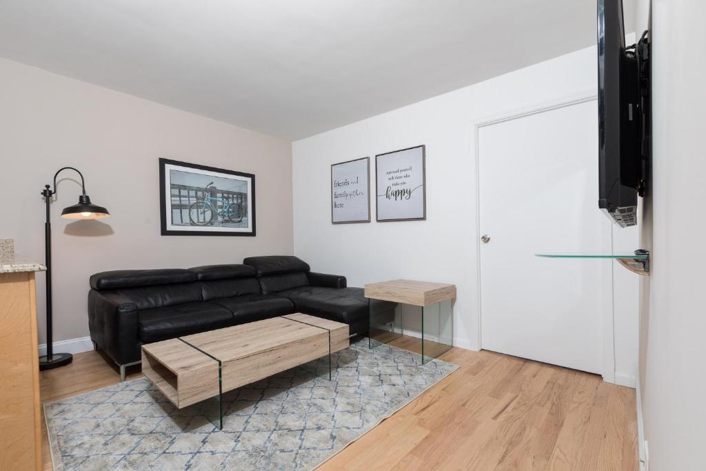 uma sala de estar com um sofá de couro preto e uma mesa em Awesome 2 Bedroom Apartment in NYC em Nova Iorque