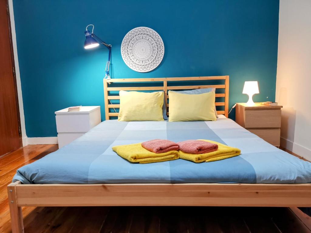 um quarto azul com uma cama com duas toalhas em Tradicional Portuguese Apartment em Lisboa