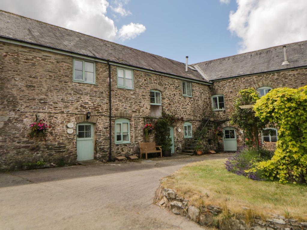 a large brick building with white doors and windows at Blackberry Cottage in Kingsbridge
