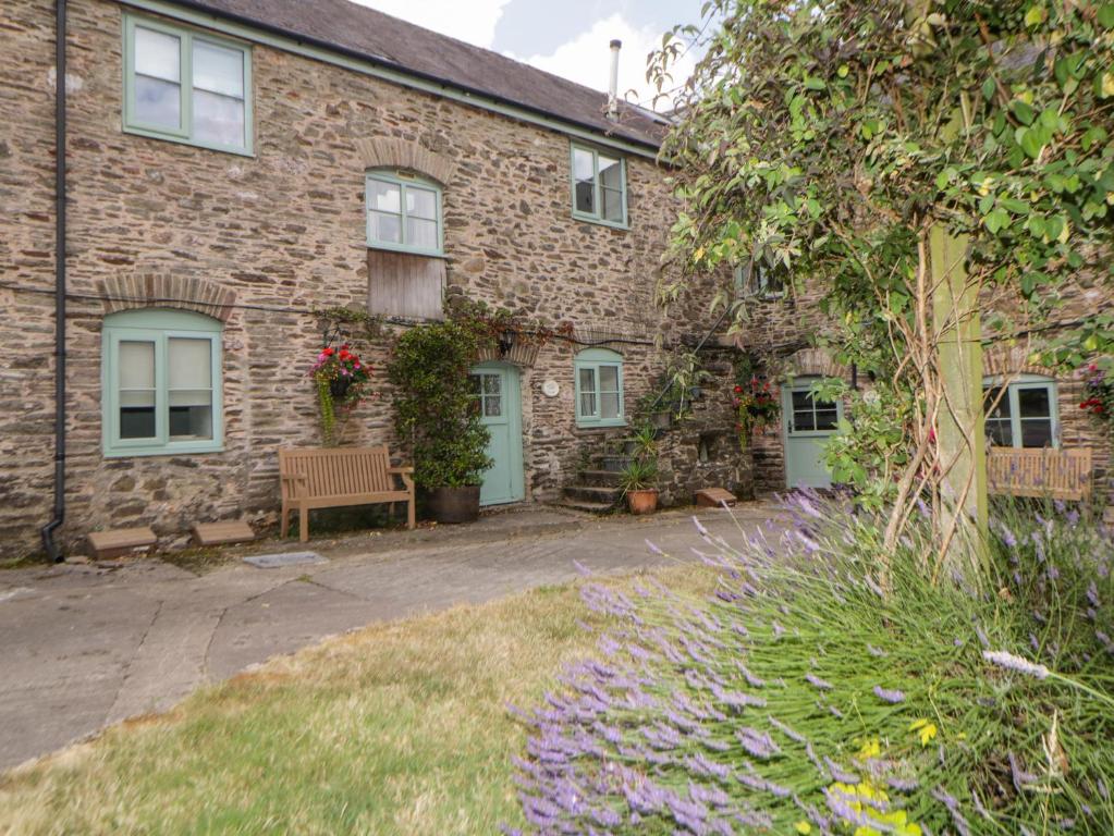 a brick house with a bench in front of it at Blackberry Cottage in Kingsbridge