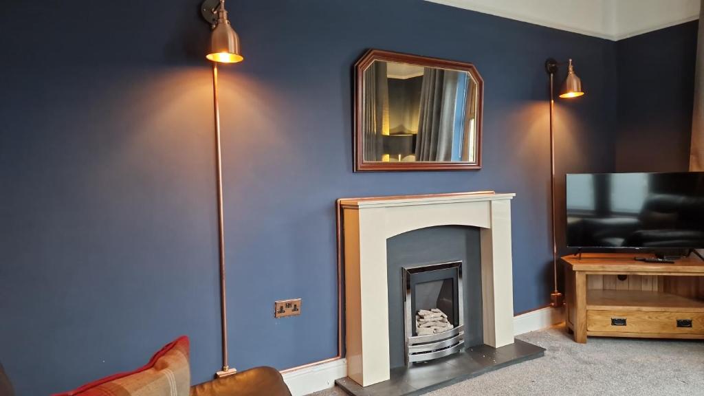 a living room with a fireplace and a mirror at Carr Garth in Arnside