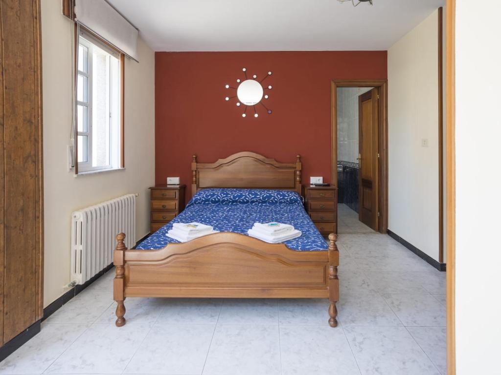 ein Schlafzimmer mit einem Holzbett in einem Zimmer in der Unterkunft Pensión Castro Parrillada in Samos