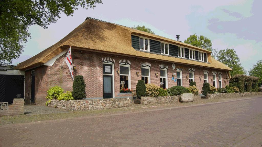 een stenen huis met een Amerikaanse vlag ervoor bij Fletcher Hotel-Restaurant de Borken in Dwingeloo