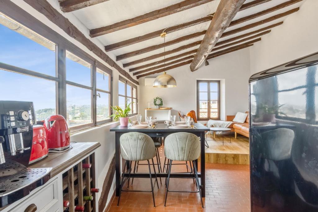 une cuisine avec une table et des chaises dans une pièce dans l'établissement Appartement des Cigales - Welkeys, à Cagnes-sur-Mer