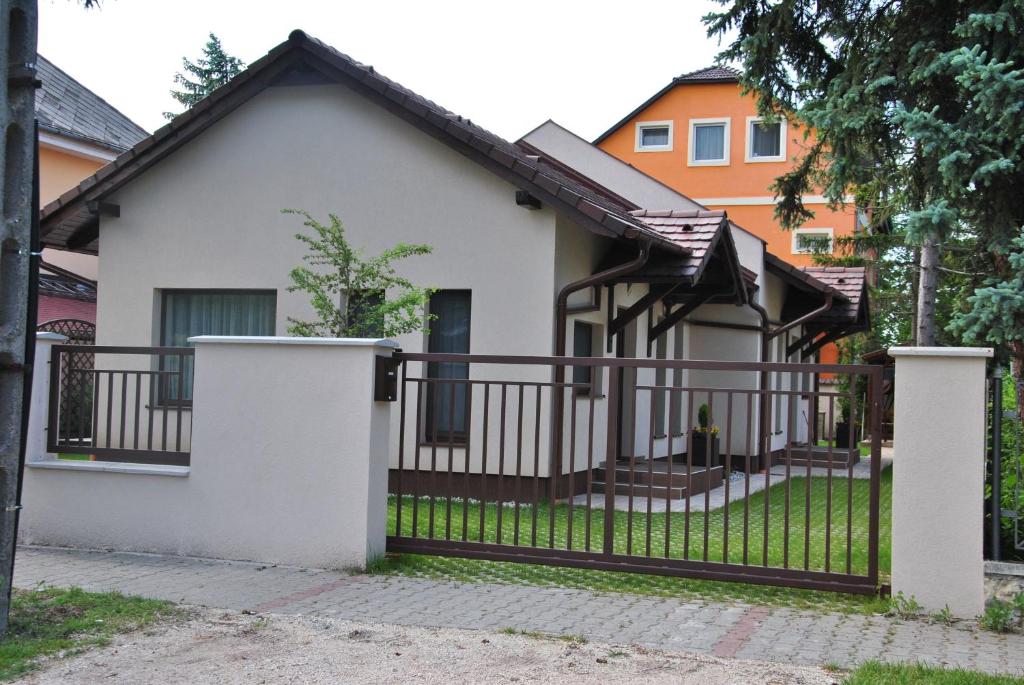 een wit huis met een zwart hek bij Panyi Apartman in Siófok