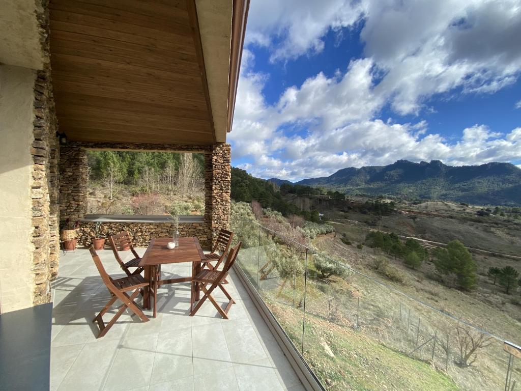 a table and chairs on a balcony with a view at Casa Rural Piedra de la Torre in Riópar