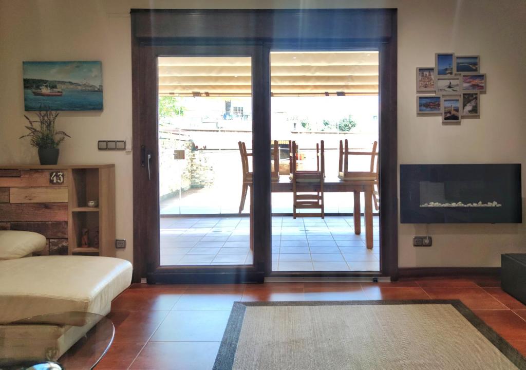 ein Wohnzimmer mit einer Tür, die auf eine Terrasse führt in der Unterkunft Desconectaengalicia Adosado Vichona a 2,5 km del centro de Sanxenxo in Sanxenxo