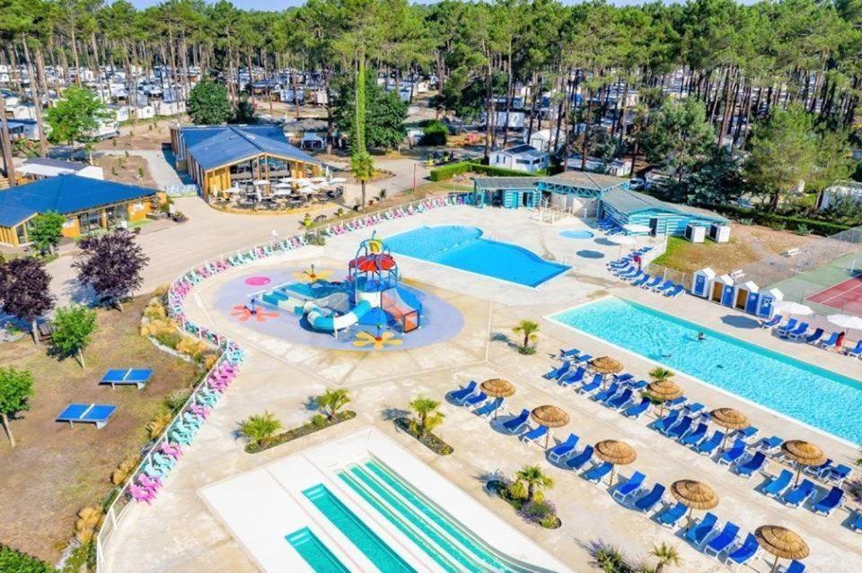 uma vista superior de uma piscina num resort em Plage de Contis, Camping SIBLU 3*, parc aquatique, piscines chauffées. em Saint-Julien-en-Born