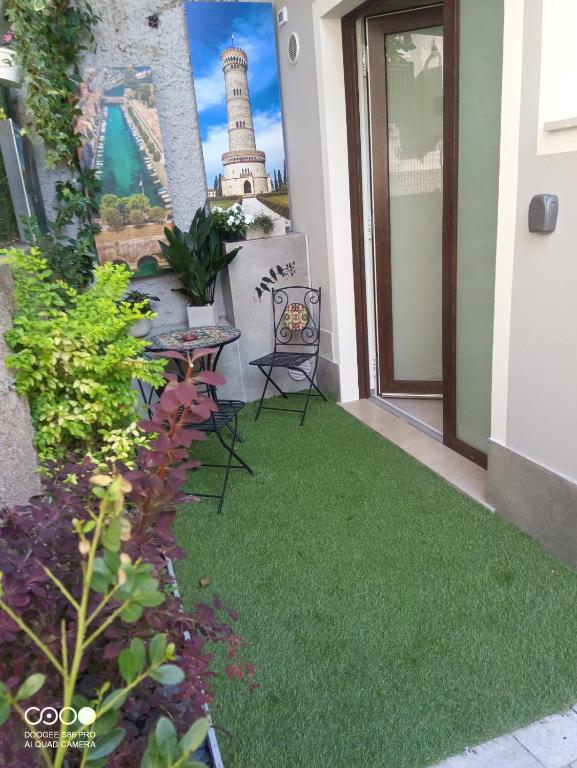 a balcony with a lawn with a lighthouse in the background at Civico 6 in Peschiera del Garda