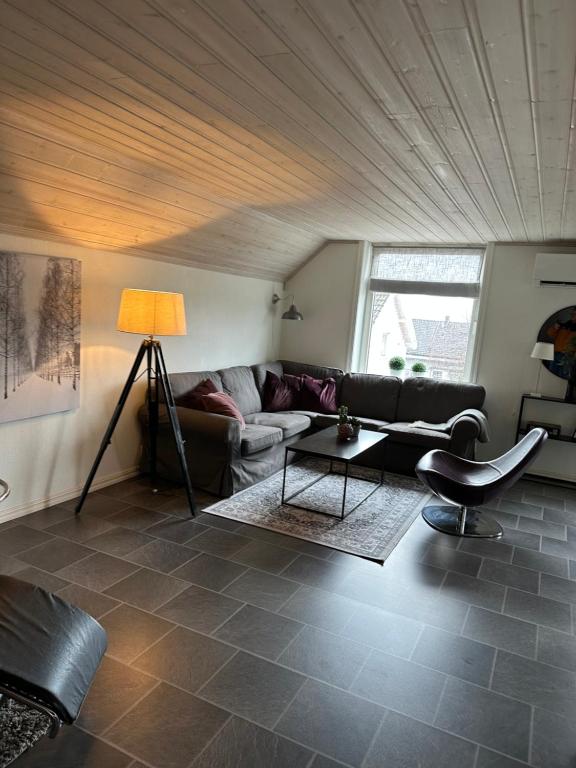 uma sala de estar com um sofá e uma mesa em Kirkegata 7 em Sarpsborg