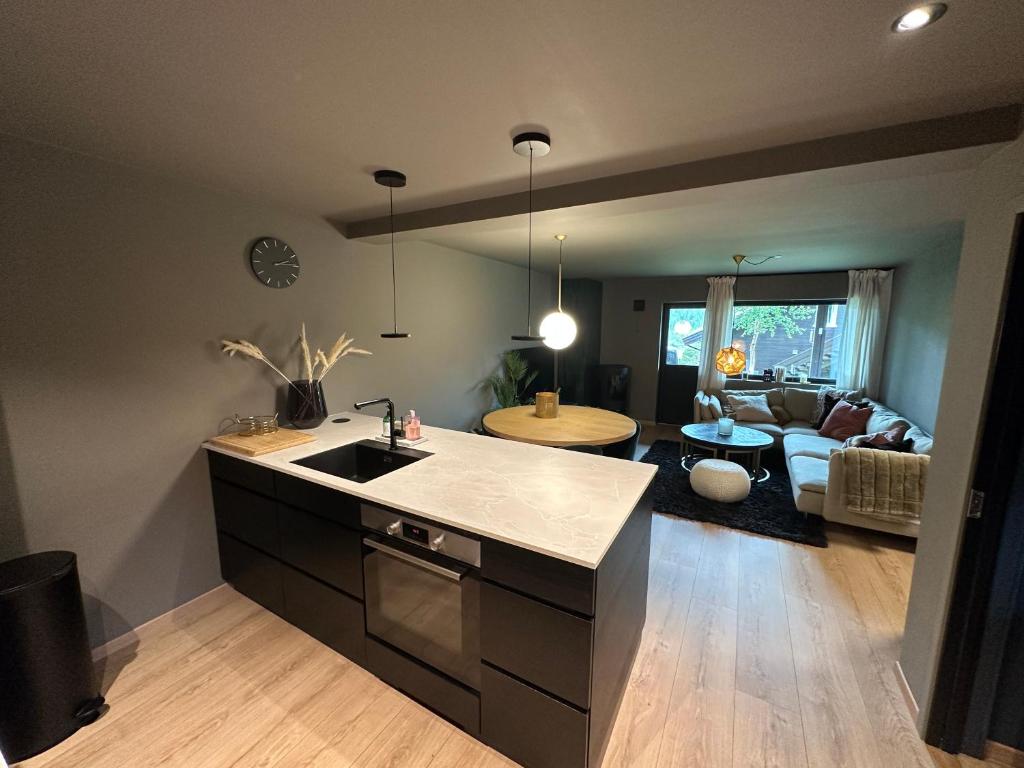 a kitchen with a sink and a living room at SKI INN/OUT - 4-room apartment w/3 bedroom in Gaustablikk