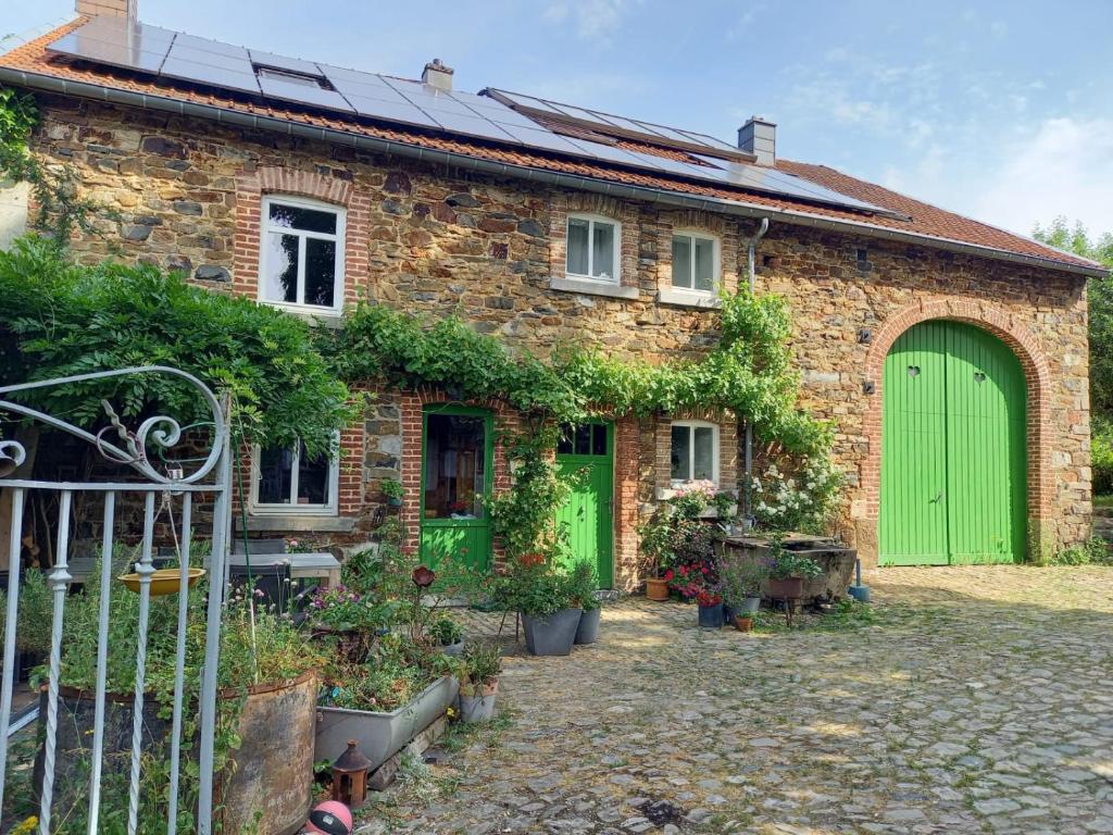 una casa de ladrillo con puertas verdes y un patio en Le Wayai en Sart-lez-Spa