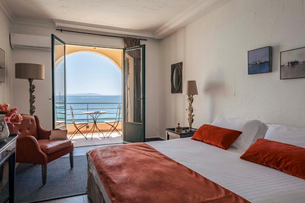 a bedroom with a bed and a view of the ocean at Surplage Hotel Cavalière in Le Lavandou
