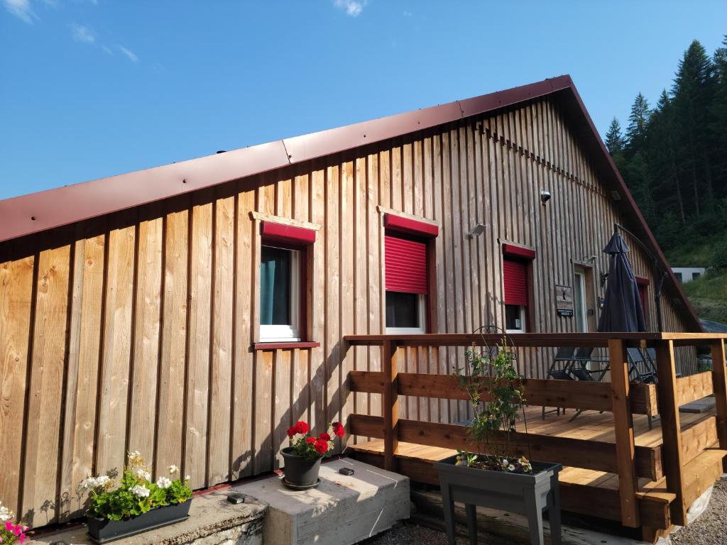 a building with a wooden fence and some plants at La ferme du Badon in Gérardmer