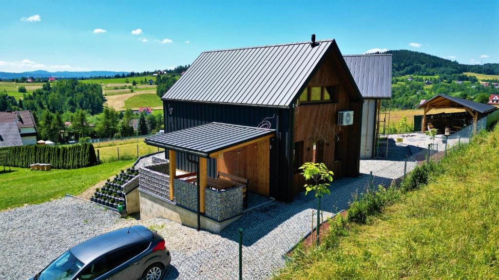 una piccola casa con una macchina parcheggiata di fronte di Domki pod Luboniem a Rabka-Zdrój