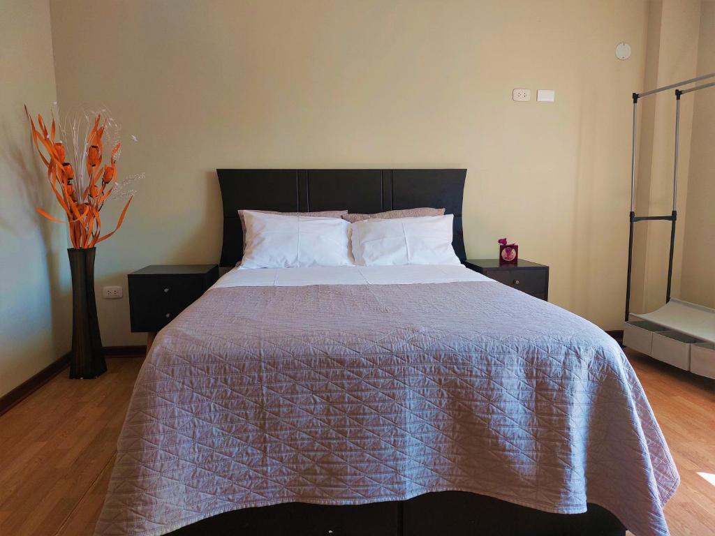 sypialnia z dużym łóżkiem z fioletową kołdrą w obiekcie Casa Mahulu w mieście Paracas