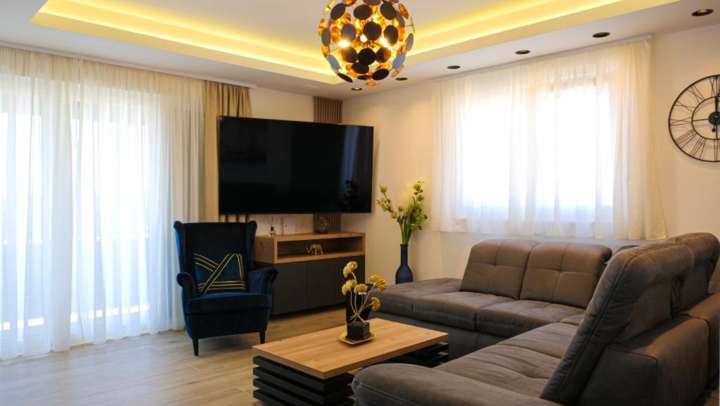 ein Wohnzimmer mit einem Sofa und einem Flachbild-TV in der Unterkunft Luxury penthouse SkyView in Trogir