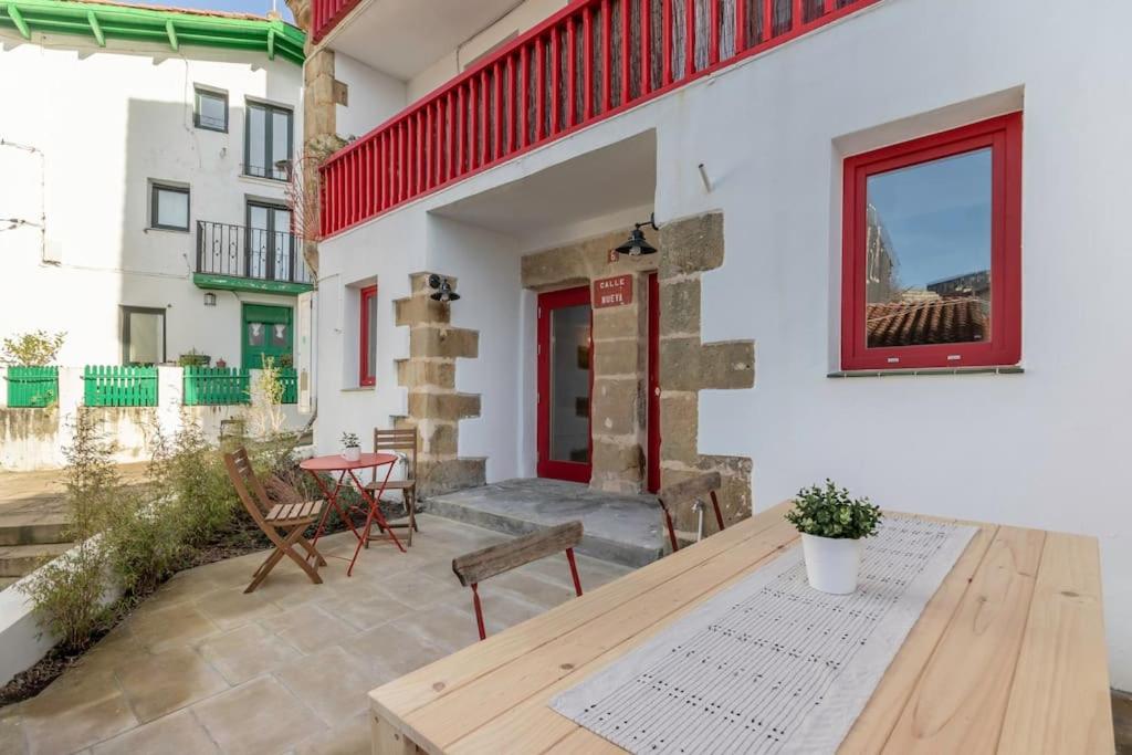 a patio with a wooden table and chairs on a building at Apartamento Basartena I Puerto Viejo in Getxo