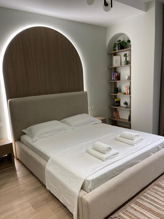 a bedroom with a large bed with two towels on it at Deluxe Residence in Durrës