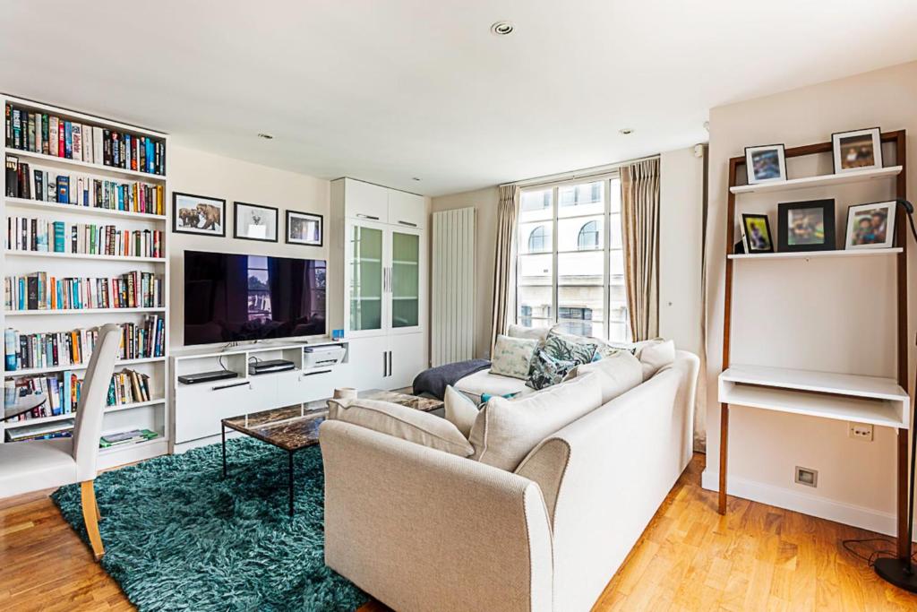 een woonkamer met een bank en een tv bij Luxury and Modern Bayswater Apartment in Londen