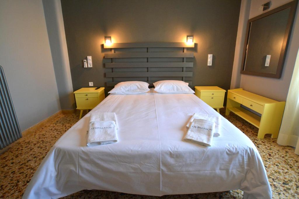 um quarto com uma cama grande com duas toalhas em Leonidaion Guesthouse em Olympia