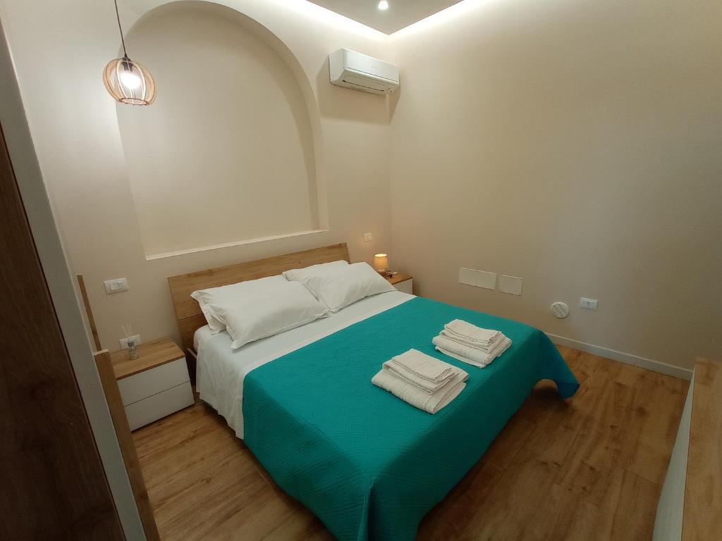 Suites Elifani في تراني: غرفة نوم بسرير ازرق عليها منشفتين